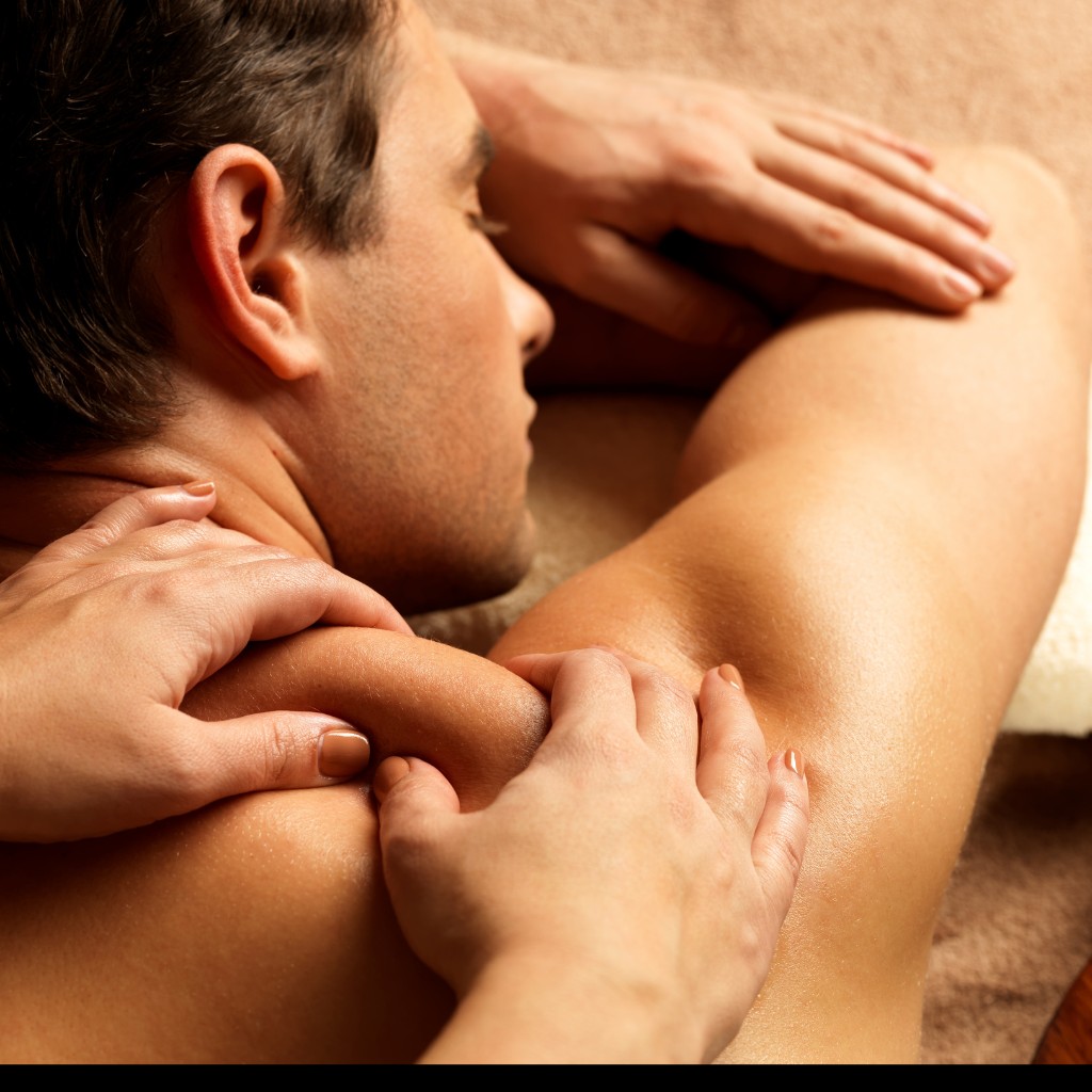 Female therapist performing a deep tissue massage on a male client to relieve muscle stiffness and tension